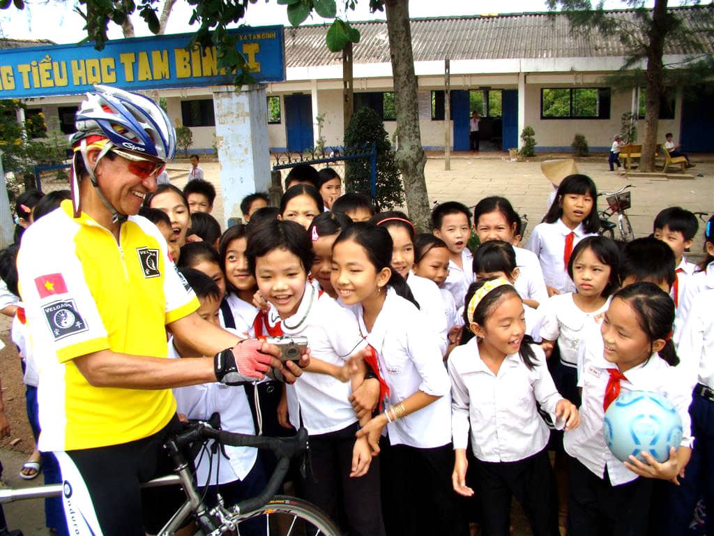 Bicyclist stops at local school in Vietnam